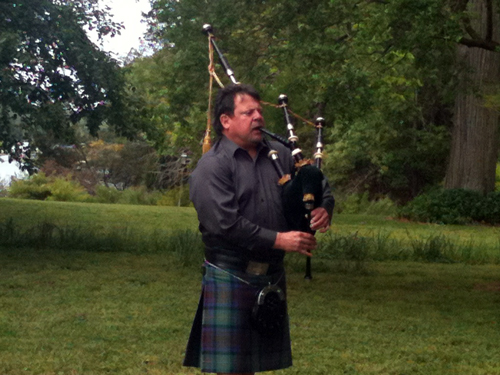 Tim Carey playing bagpipe at the garden